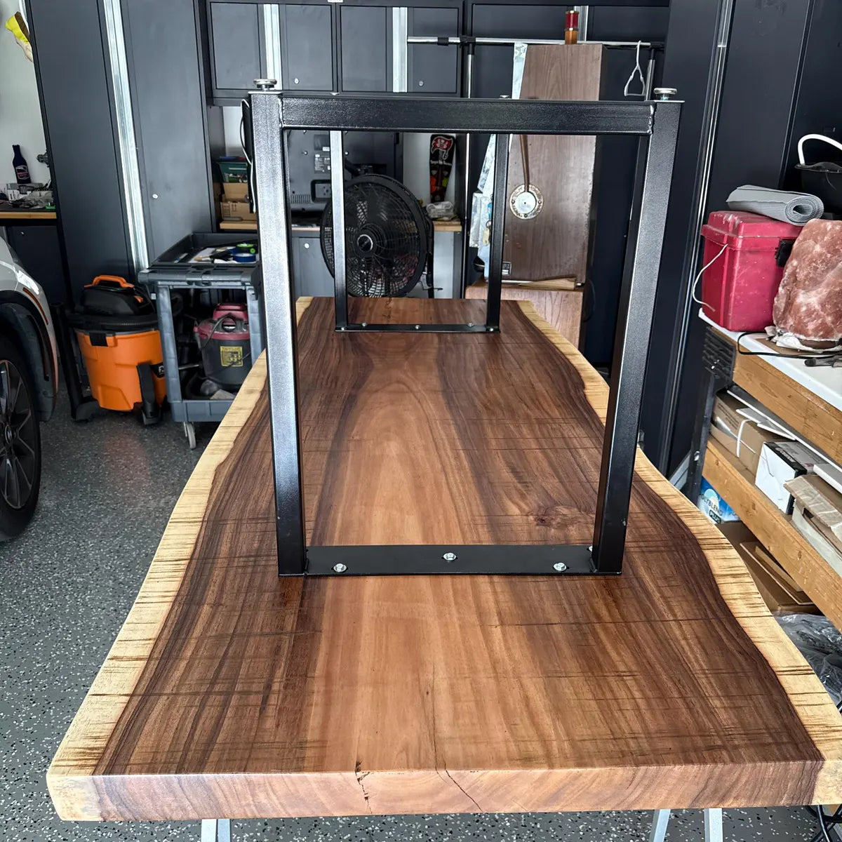 Wooden table with black metal frame in a workshop setting