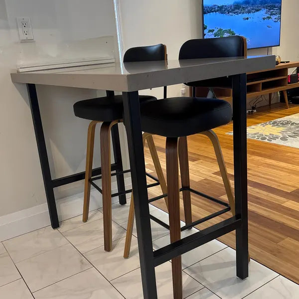 High table with stools in a room with a TV in the background